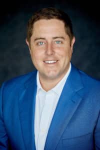 Charles Christensen headshot in navy blue suit